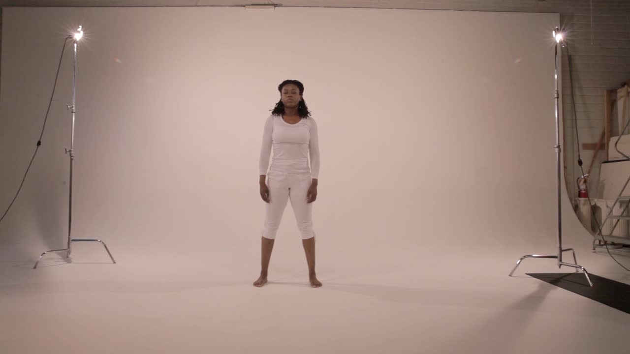 una yogini pasa suavemente a la postura de la montaña