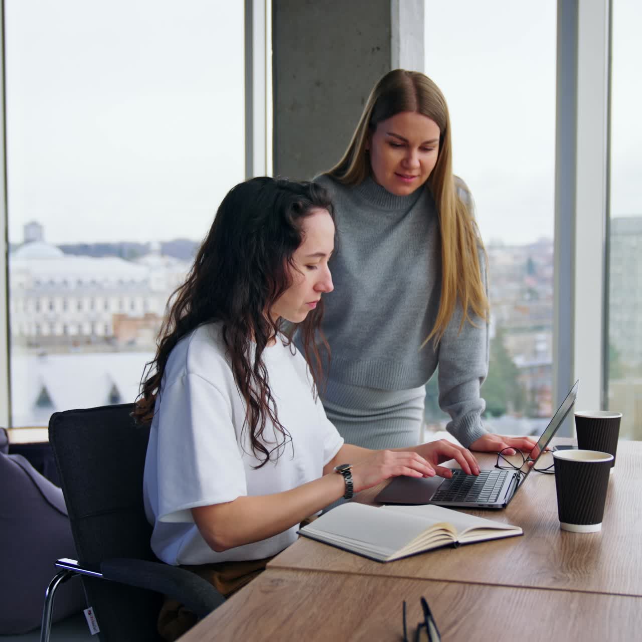 Writing letters to the clients. Two female colleagues communicate and make up an official message to the partners