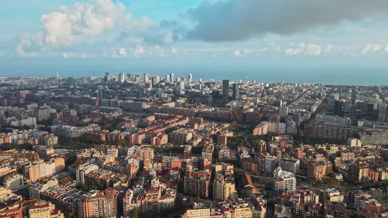 Aerial drone view of Barcelona, Spain. Blocks with multiple residential buildings, Mediterranean sea in the distance