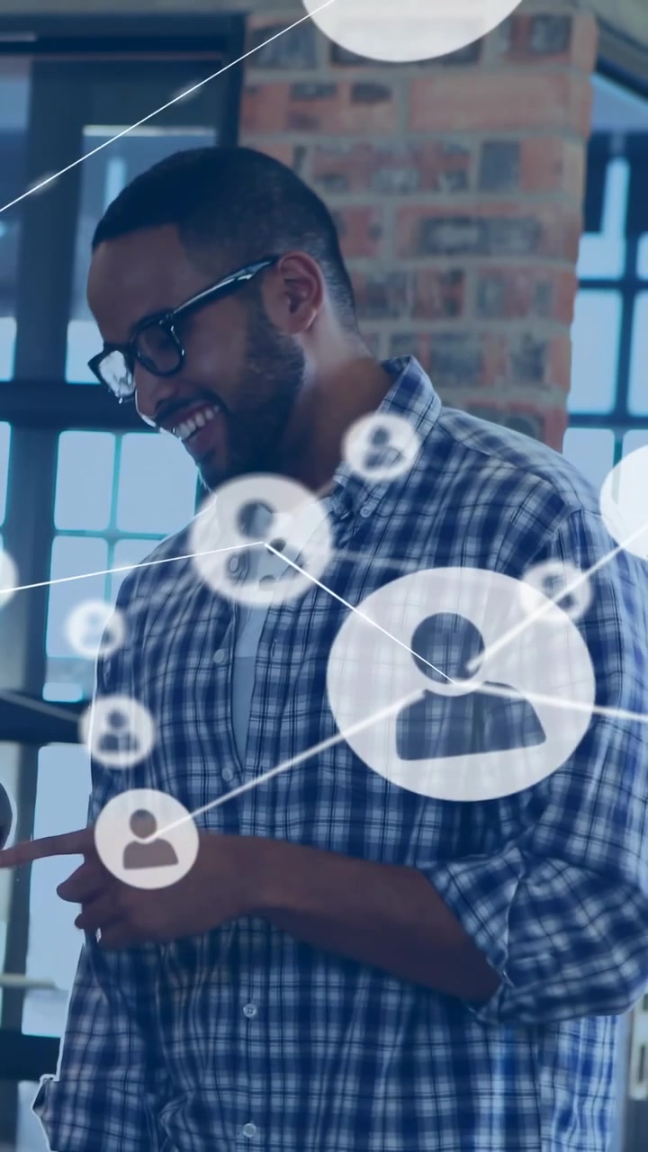 Vertical video: Man tapping phone in tech loft, starting AR icons and lines showing team network