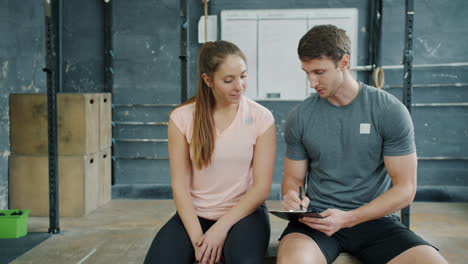 personal trainer consulting with client in gym