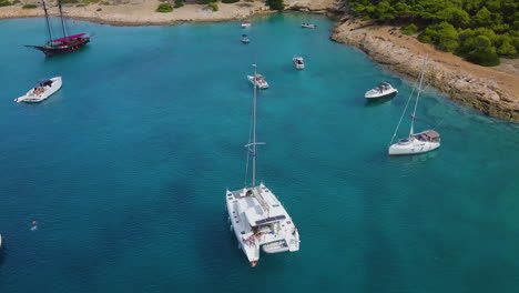 Reveladora-Toma-De-Drones-De-Un-Catamarán-Amarrado-Y-Gente-Buceando-En-El-Mar-Cerca-De-La-Bahía