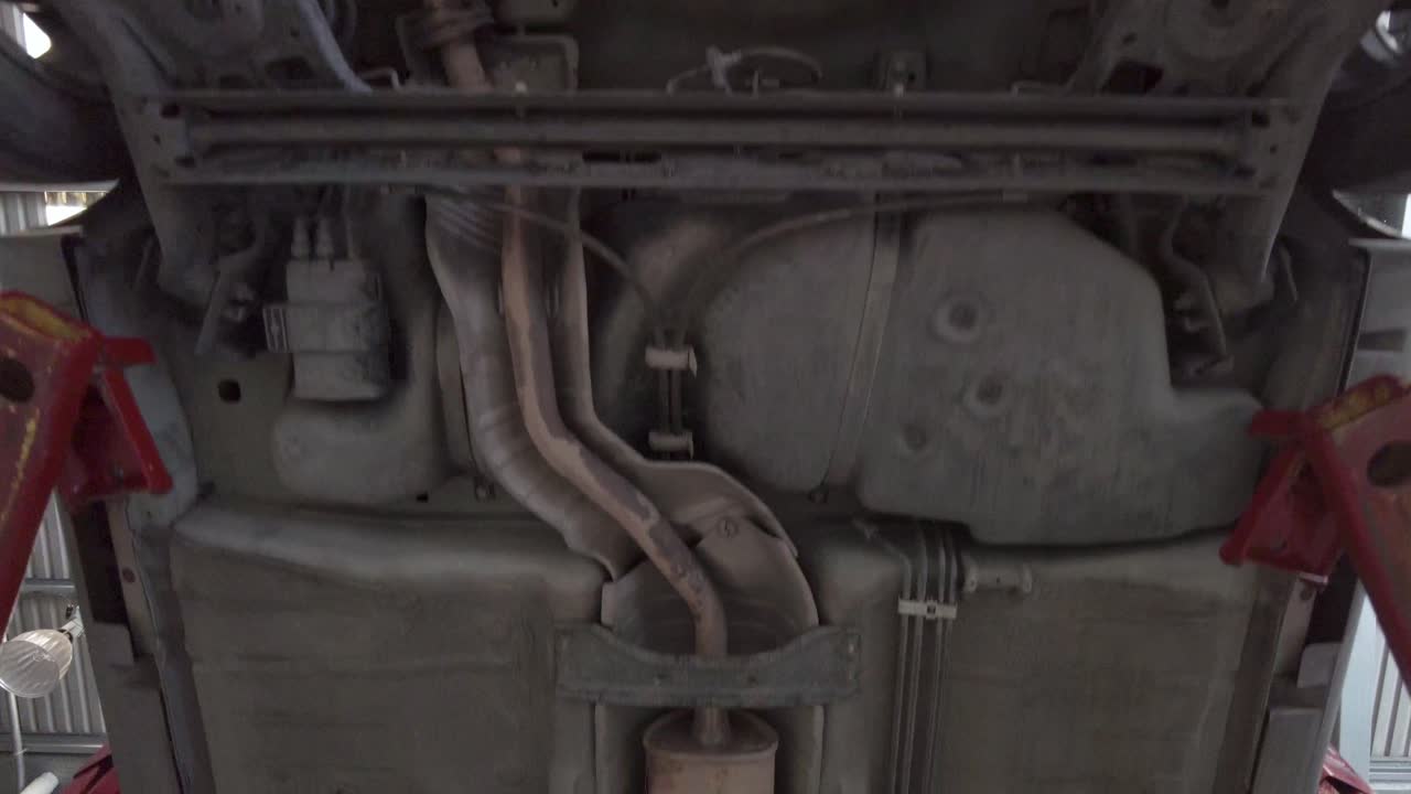 la parte inferior del chasis de un automóvil transportado por un elevador de automóviles en una estación de taller en puebla, méxico, américa latina