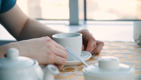 person enjoying a cup of tea at a cafe