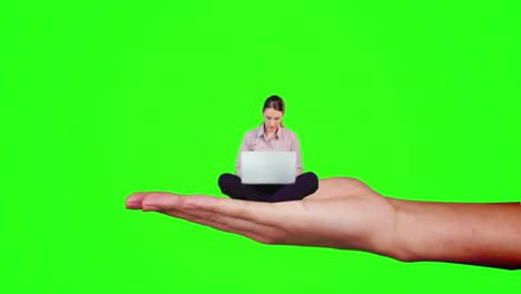 Hand-holding-sitting-businesswoman-focused-on-laptop-against-green-screen-