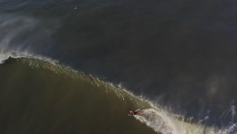 aerial: surfer bodyboarding wave and bailing out of large crashing break