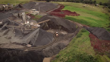 top down view on open stone quarry, piles and excavators working around near iguazu river, brazil