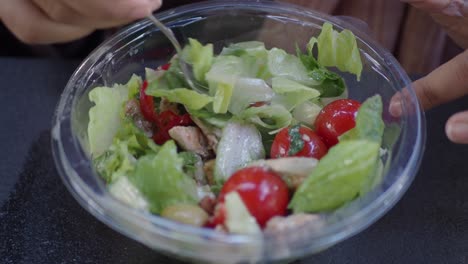 persona comiendo una ensalada de pollo