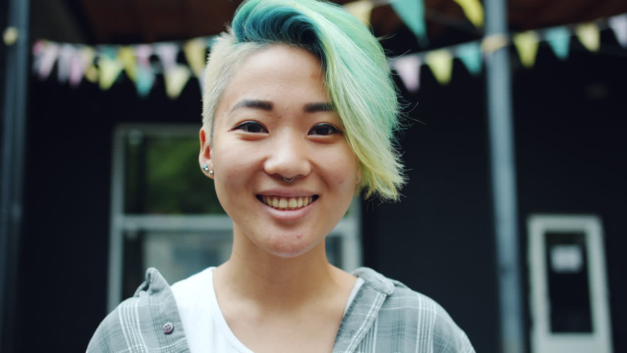 Smiling woman with vibrant blue and green hair