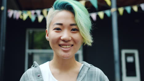 smiling woman with vibrant blue and green hair