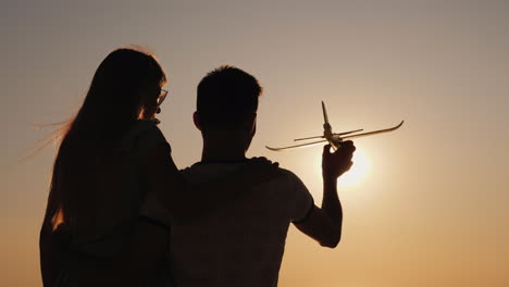 hombre y niño juegan con un avión de juguete