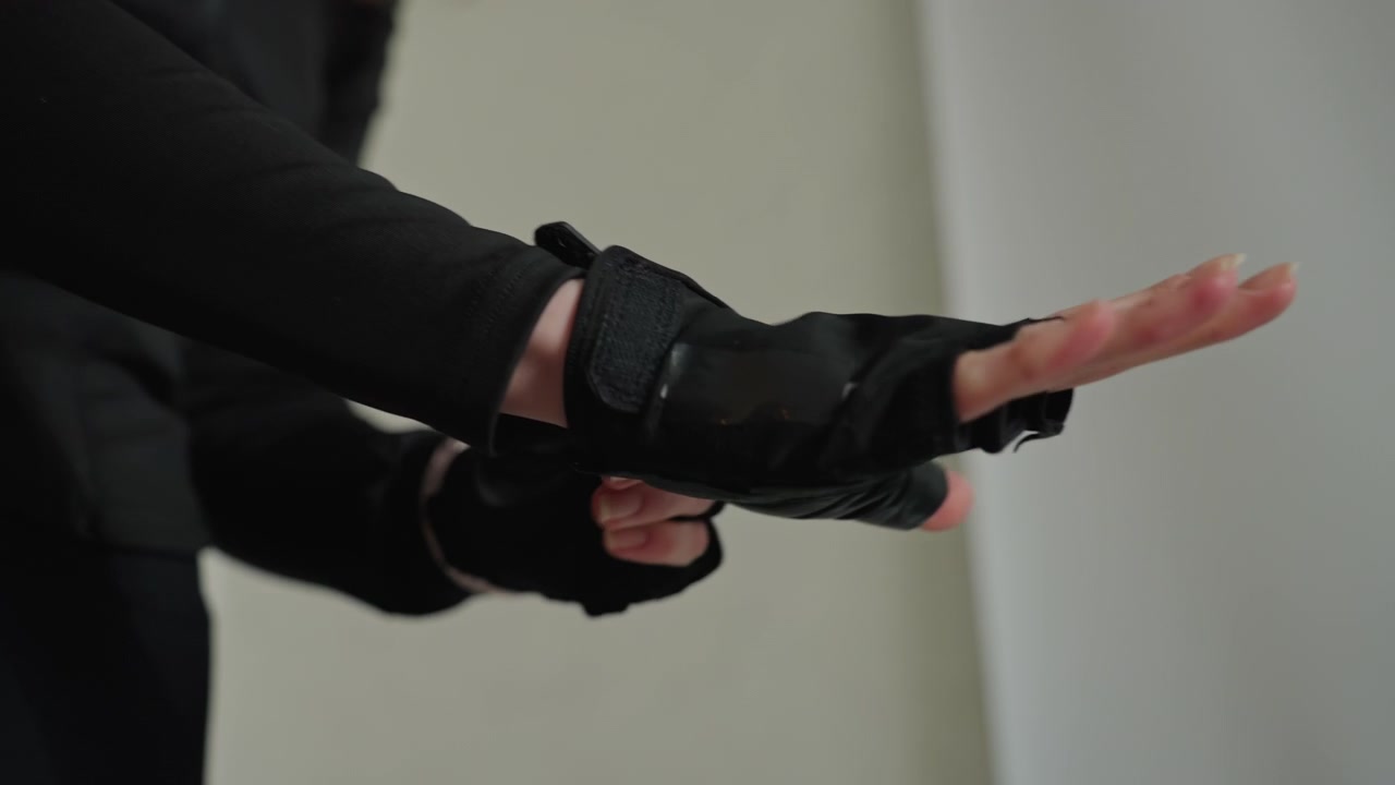 Detail shot of training glove straps. Female athlete adjusting leather gloves before workout session. Caucasian woman securing her training gloves meticulously in home exercise environment