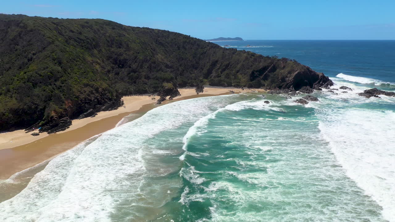 Ripresa drone delle onde dell'oceano che si infrangono a Broken Head Beach, Australia.