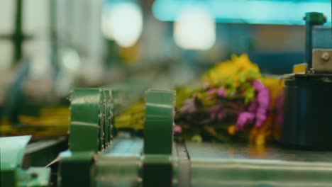 florist placing bouquets of colored flowers on a mechanical belt