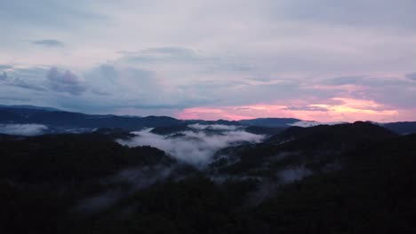 arial shot of the great smokey mountains with low lying clouds and a pink sunset