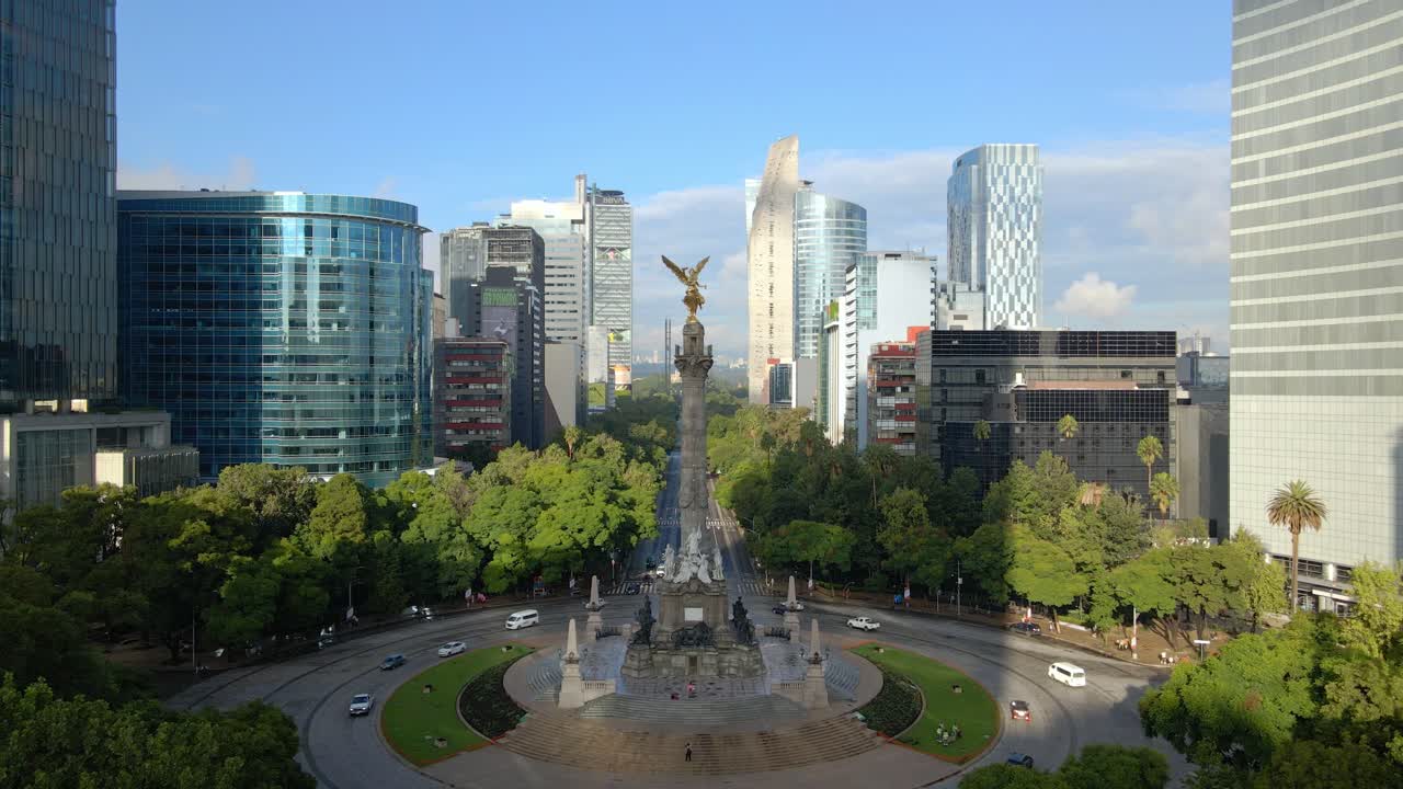 Aerial dolly out shot at the Angel of Independence roundabout on Paseo de la Reforma in Mexico City with low traffic and on a sunny day