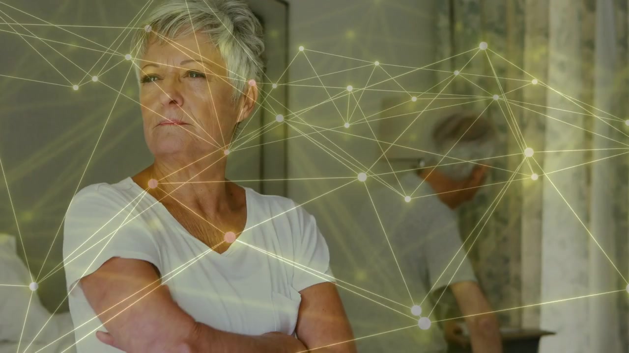 Donna anziana che alza la mano e si gira verso il partner dopo che i nodi si illuminano, monitorando la tecnologia sanitaria.