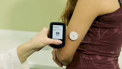 doctor with an insulin pump connected in patient abdomen and holding the insulin pump at his hands. diabetes concept.