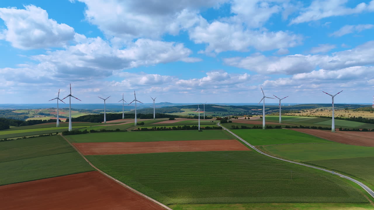 Agricultural fields with wind farms. Renewable energy production. Aerial perspective