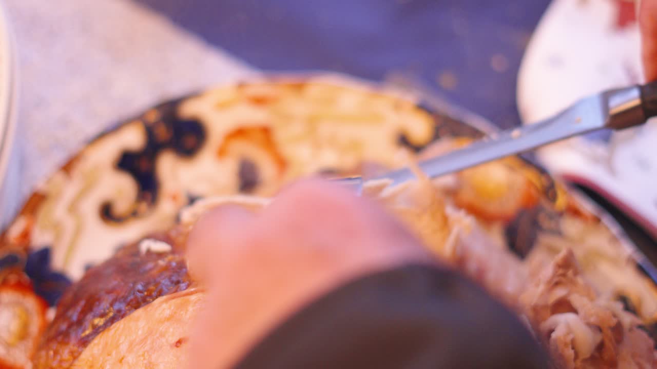 Vista dall'alto di carne di tacchino affettata al tavolo da pranzo dopo essere stata arrostita nel forno, pronta per essere servita per il pasto di Natale o del Ringraziamento con la famiglia a casa per le feste 4K