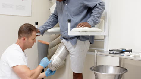 technician fitting prosthetic leg for patient in medical lab setting