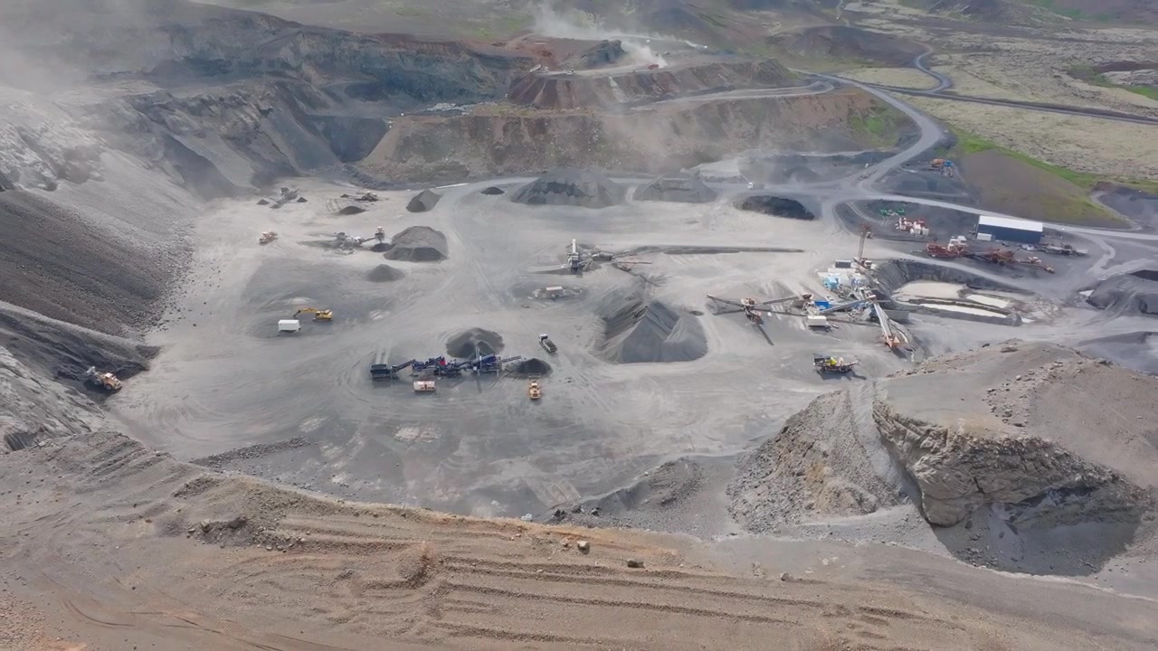 Backward drone flight reveals gravel piles across Reykjanes Iceland quarry