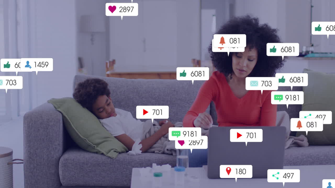 Using laptop with social media notifications, woman beside child resting on couch