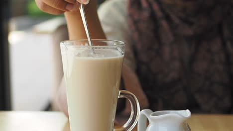 alguien mezclando un latte