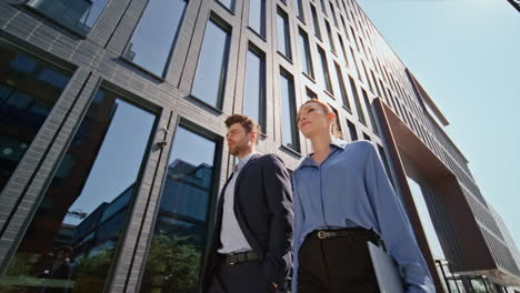 confident company partners walking urban street. two colleagues going at work