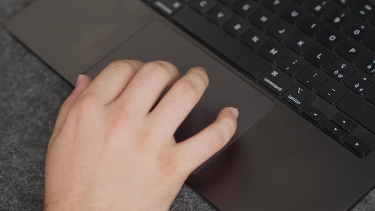 Close-up hand gesture on MacBook Pro M4 trackpad, sleek modern design indoors