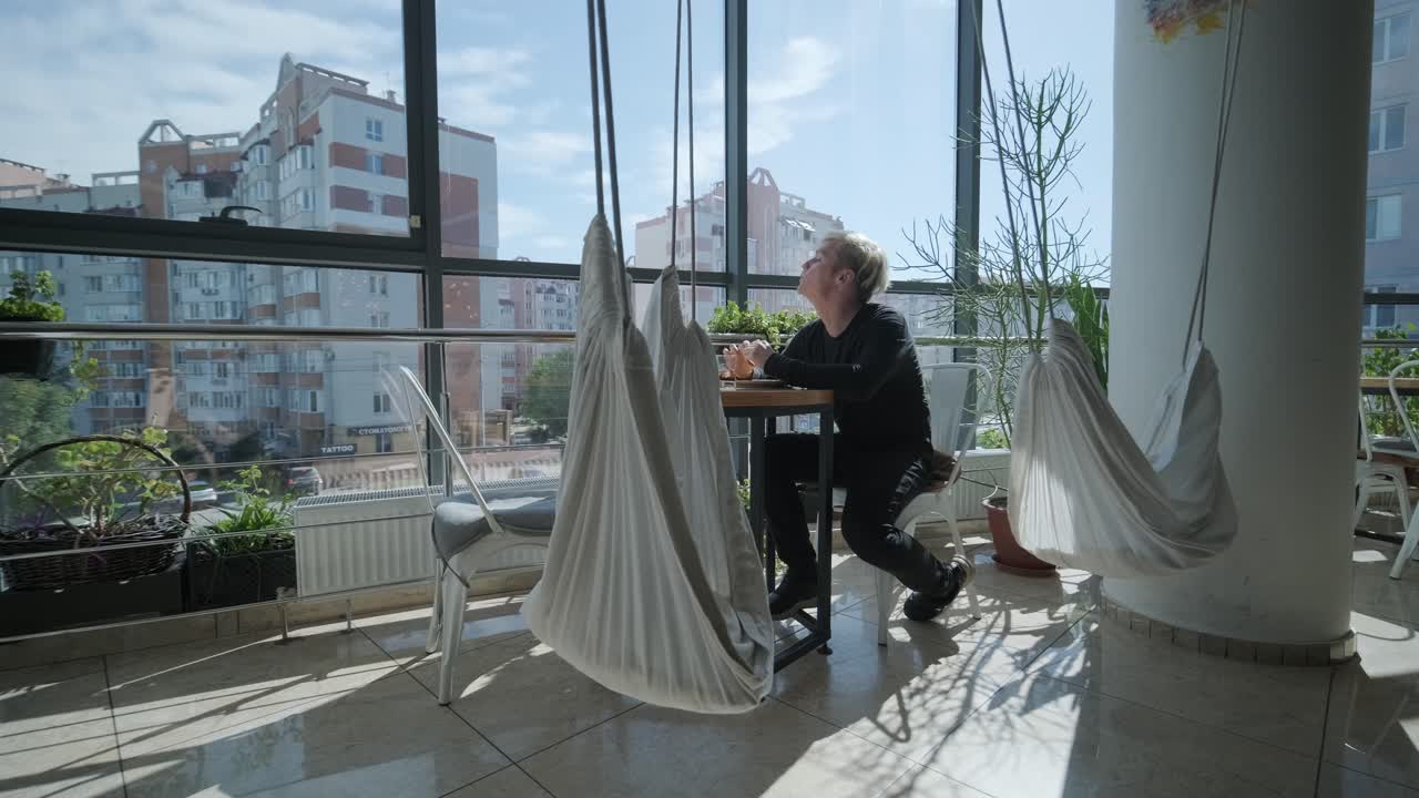 hombre relajándose en un café moderno con vistas a la ciudad