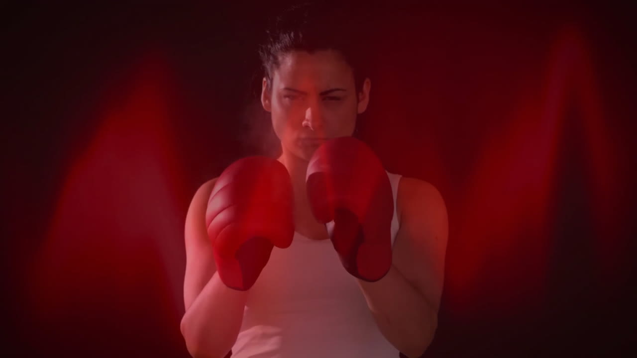 Woman boxing with red gloves in fitness studio, merging animated red light waves with smoke haze