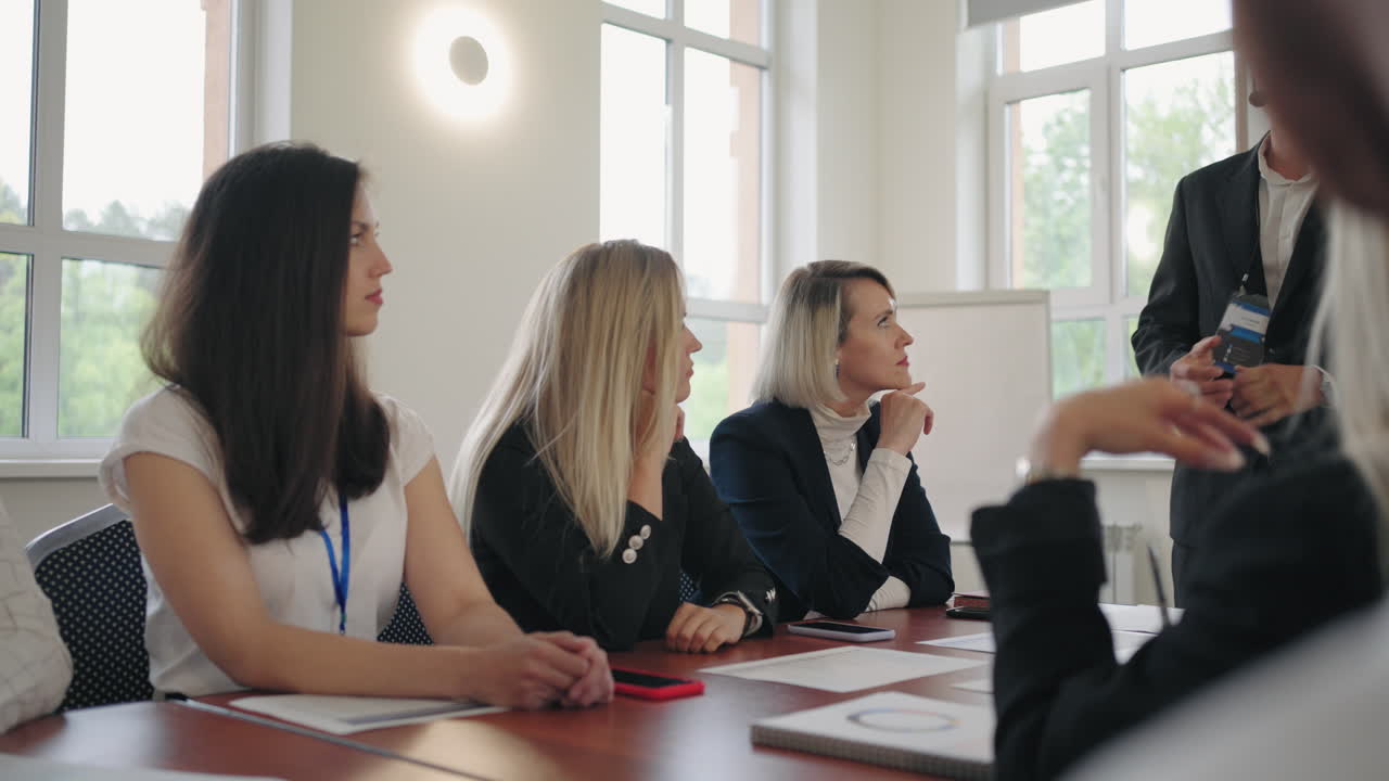 여성과 남성은 마케팅에 대한 전문 교육 과정에서 비즈니스 코치를 듣고 있습니다.