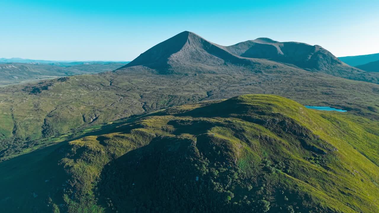 Aerial view of mountains and green hills on a sunny day