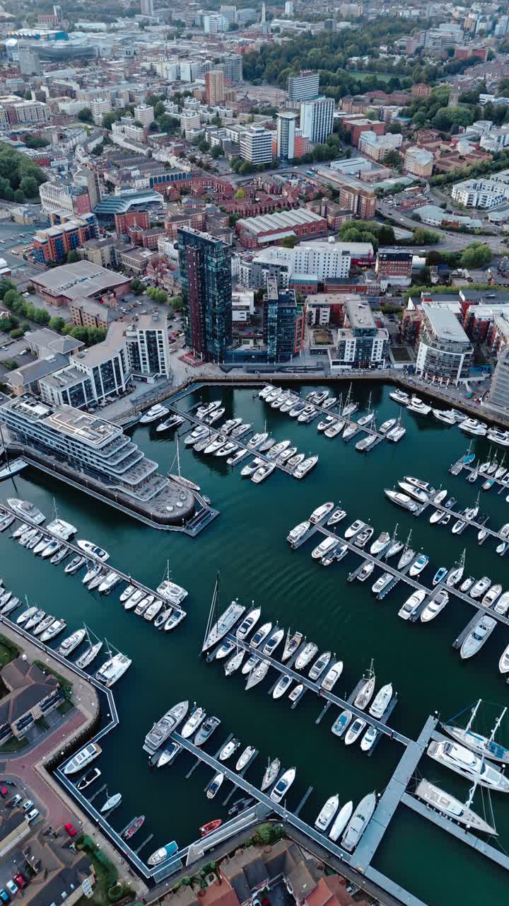 Aerial drone footage of Ocean Village marina in Southampton, showcasing boats, docks, buildings, and waterfront real estate under soft daylight at sunset shot during autumn