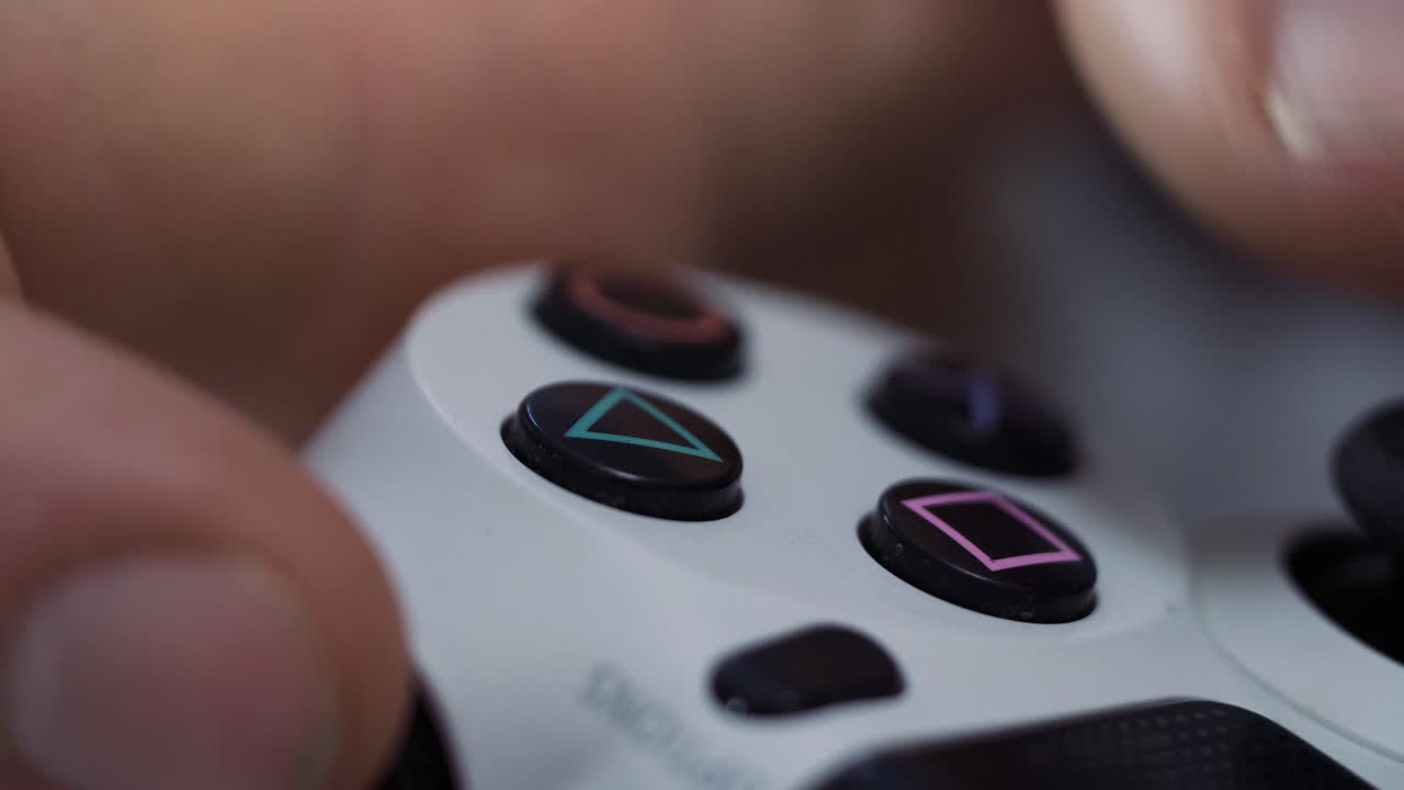 Close-up of a person's hand holding and using a video game controller