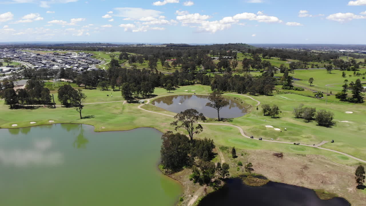 골프 카트는 화창한 날 아름다운 코스를 통과합니다.