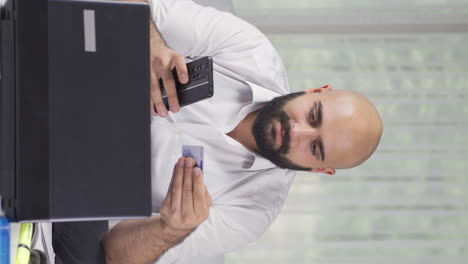 vertical video of home office worker man shopping on the phone.