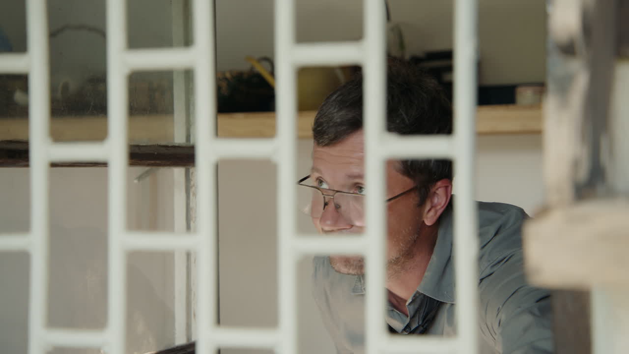 Man looking through a window grid