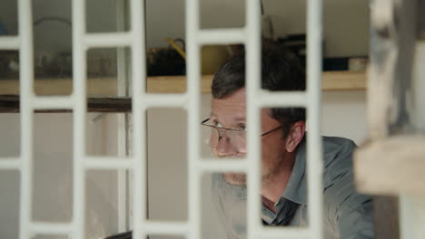 man looking through a window grid