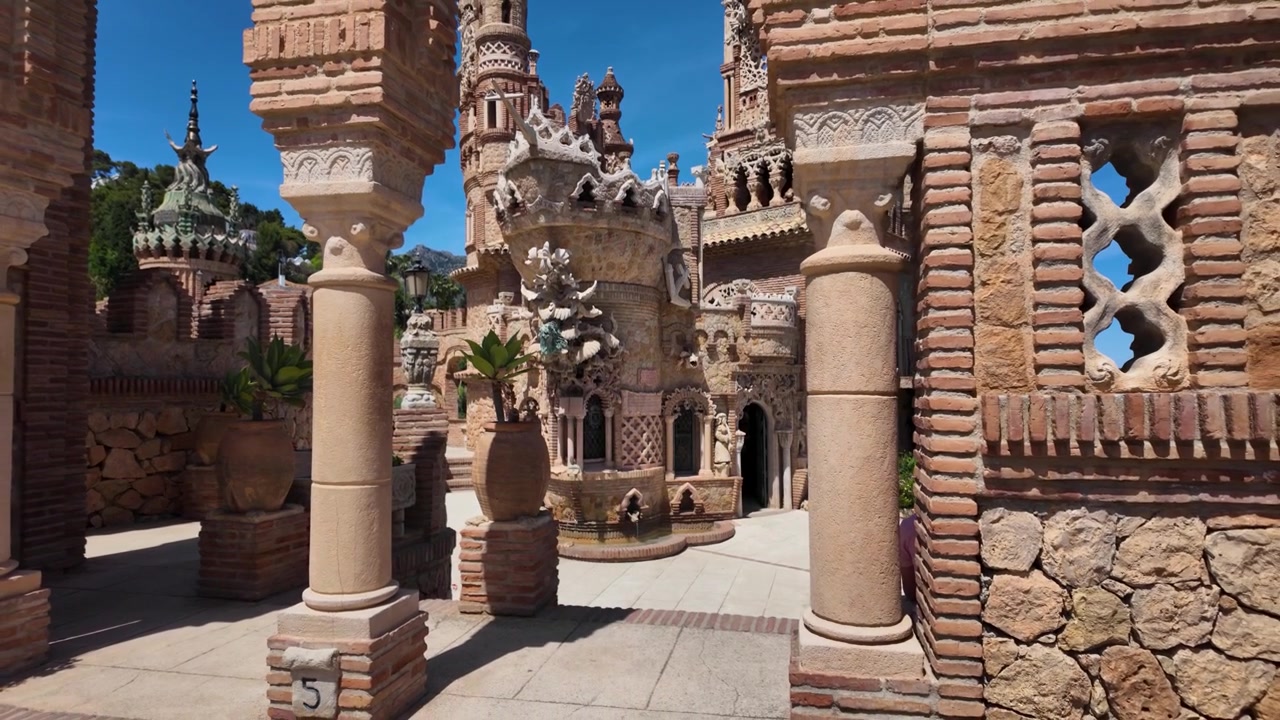 Ripresa aerea in slow motion con allontanamento che rivela il cortile e i dettagli architettonici del Castello di Colomares a Benalmádena, Spagna
