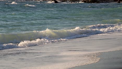 ondas oceánicas en movimiento lento chocando contra la playa de arena durante el día