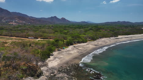 aerial view along a coast of burnt forest and a beach in sunny costa rica