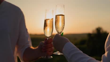 paar mit gläsern rotwein beobachten den sonnenuntergang über einem malerischen tal