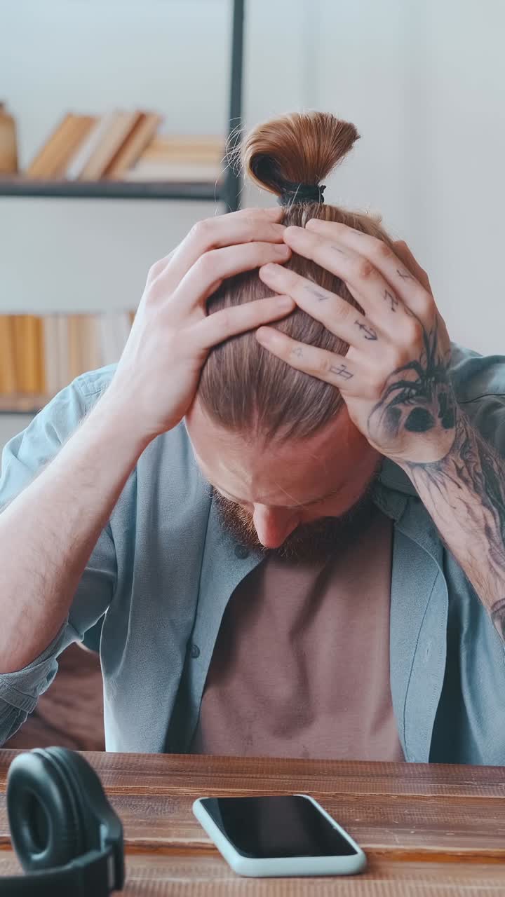 Creative man with tattoos and stylish hair exploring ideas in a cozy space