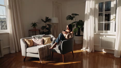 woman enjoying a hot drink in a cozy, sunlit living room