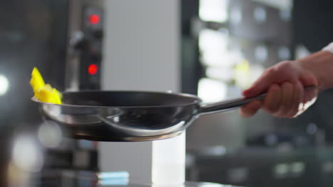 tossing vegetables on skillet while frying