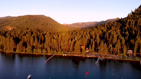 drone shot sliding forward overlooking the lake and forest during sunset
