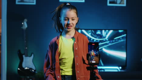 children influencer dances in studio, recording video with mobile phone for gen z internet users