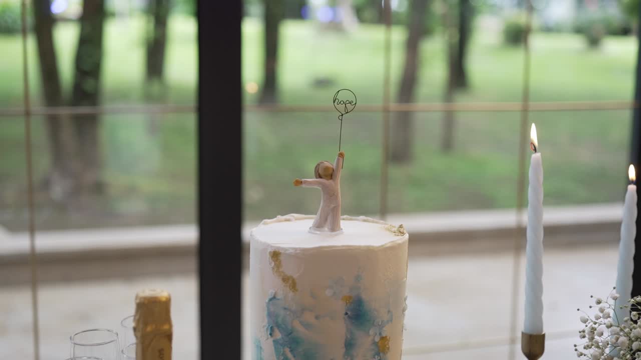 Elegante tarta nupcial con una figurita sosteniendo un globo con forma de corazón.